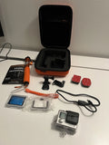 GoPro action camera kit with orange grip, mounts, waterproof case, and memory card
