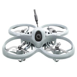 Small gray FPV quadcopter drone with four propellers, front camera and antenna mast