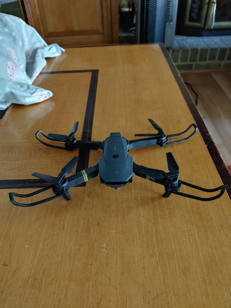 Quadcopter drone with four rotors and central camera module, dark gray body