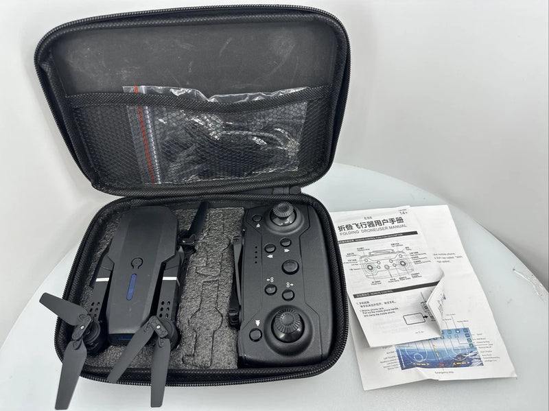 Folding drone in open black protective case with remote controller and instruction papers