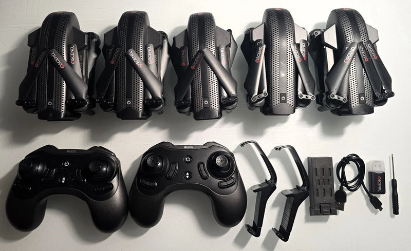 Assorted drone controller and battery charger parts with black accessories
