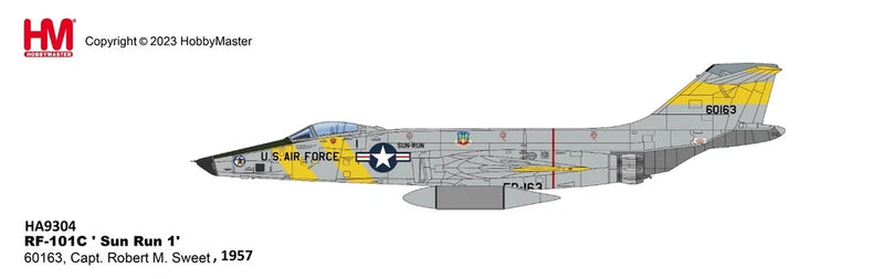 Scale model of a gray fighter jet with yellow nose and tail markings