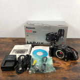 Black Panasonic LUMIX G1 mirrorless camera kit with lens, cables, battery and box