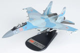 Blue fighter jet model with red markings on black display stand