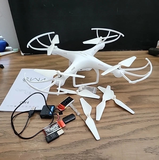 White RC quadcopter drone with 720p HD camera and spare propellers, with remote pieces