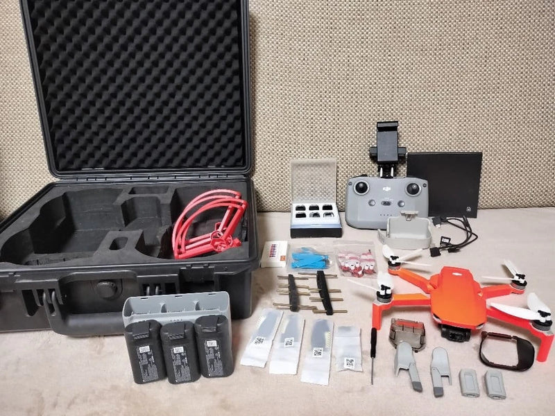 DJI Mini 2 drone with orange skin accessories and open hard case with batteries