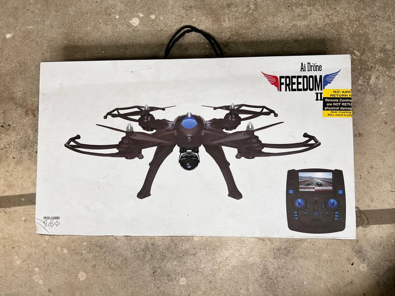 Black quadcopter drone with remote controller on product box