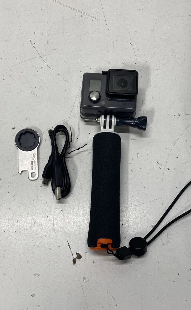 GoPro action camera with waterproof housing, foam grip handle, and charging cable