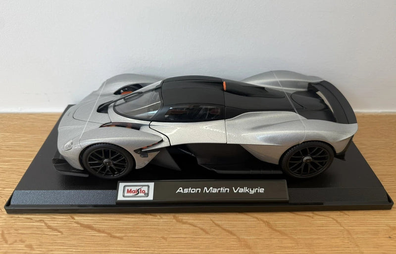 Silver die-cast model car with black aero details, on Maisto display base