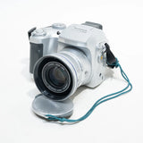 Silver Fujifilm FinePix compact digital camera with front lens and teal wrist strap