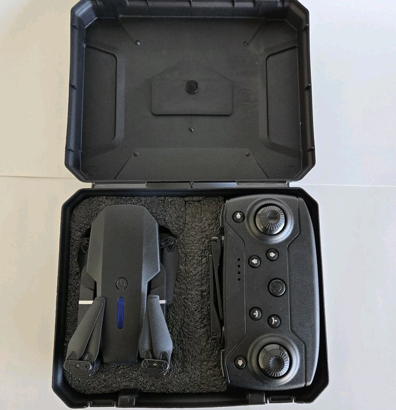 Black remote controller and drone parts in open hard case with foam padding