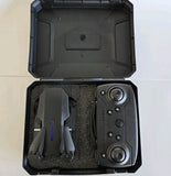 Black remote controller and drone parts in open hard case with foam padding