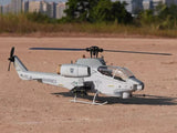 Gray RC helicopter model with spinning main rotor, skids, and tail boom details