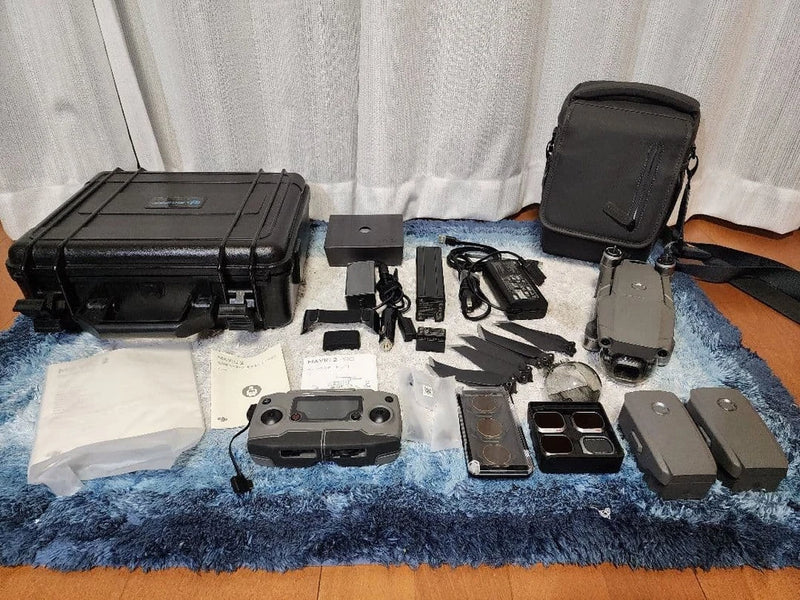 Drone accessory kit with hard case, batteries, charging hub, cables, and remote parts