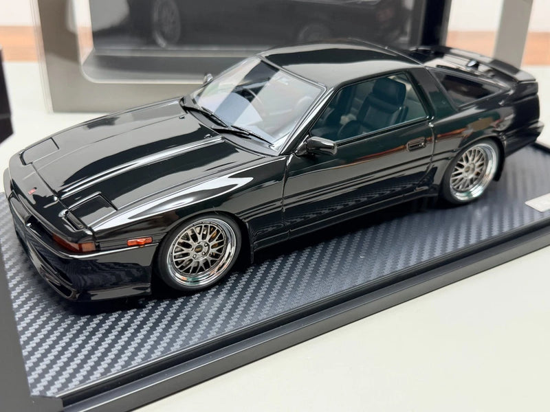 Black die-cast sports car model, front three-quarter view with chrome wheels