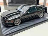 Black die-cast sports car model, front three-quarter view with chrome wheels