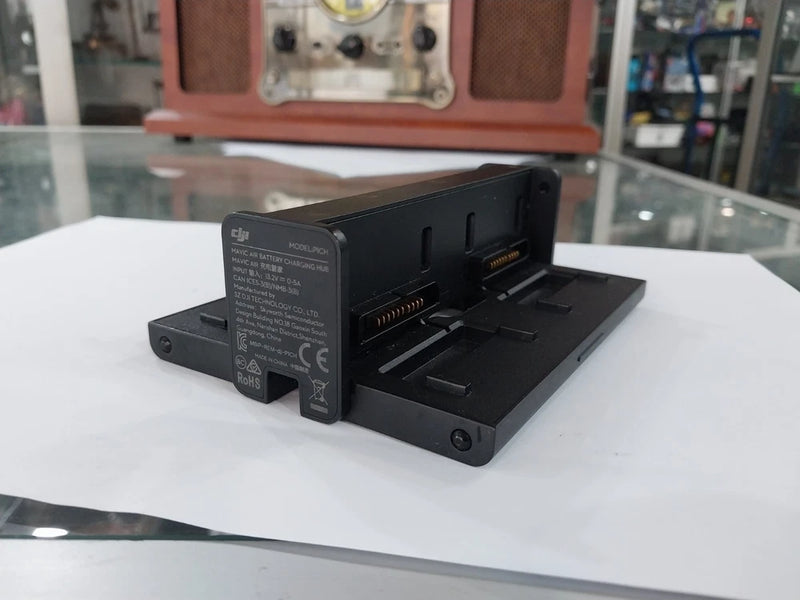 Black battery charging hub with connector ports and side slots for DJI Mavic Air 1