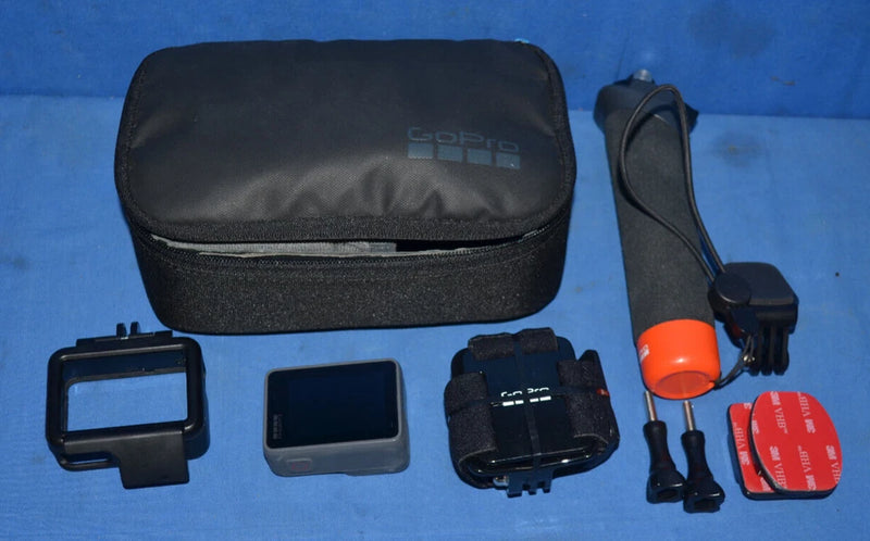 GoPro Hero action camera with black housing, mounts, red battery, and zip carry case