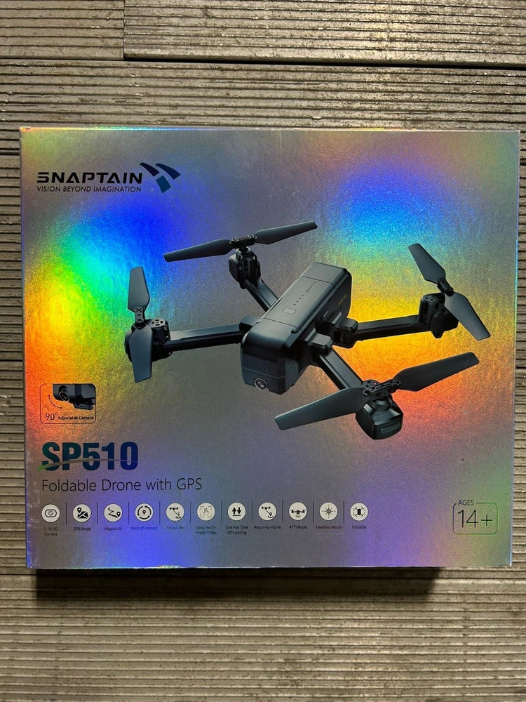 Foldable GPS FPV drone quadcopter on product box, gray body with four propellers