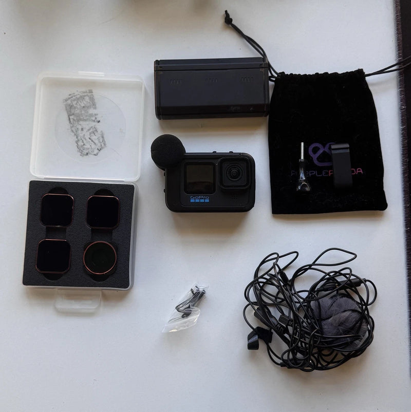 Black action camera bundle with touchscreen, charging cable, mounts, and storage pouch