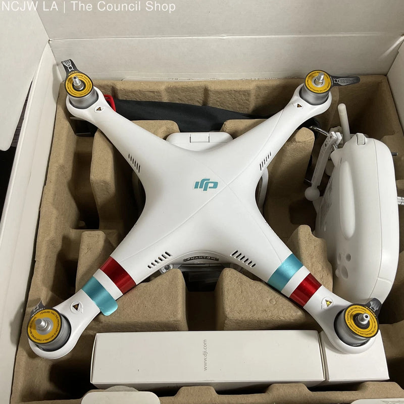 White quadcopter drone with four propellers and camera body in a shipping box