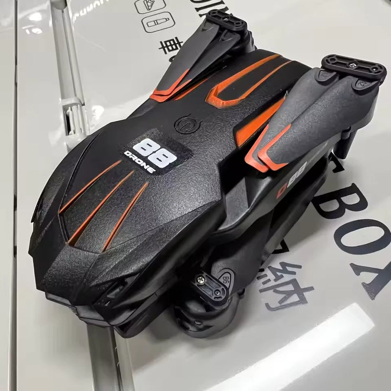 Black drone body with orange accents and camera mount, prop guards visible