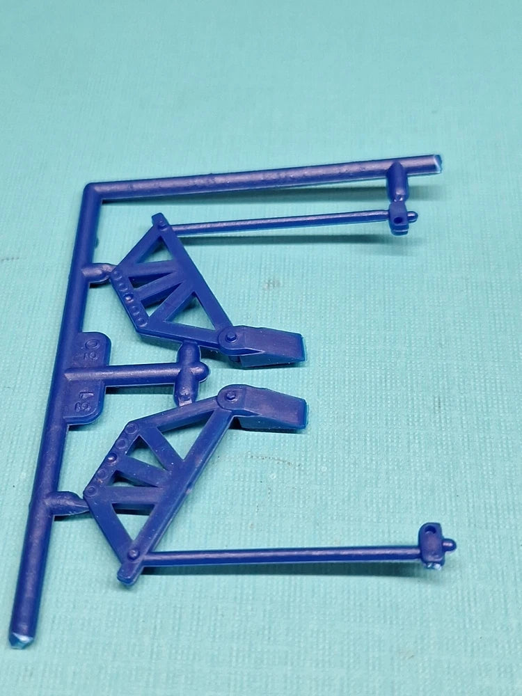 Dark blue monster truck model shock linkage and bell crank parts on sprue