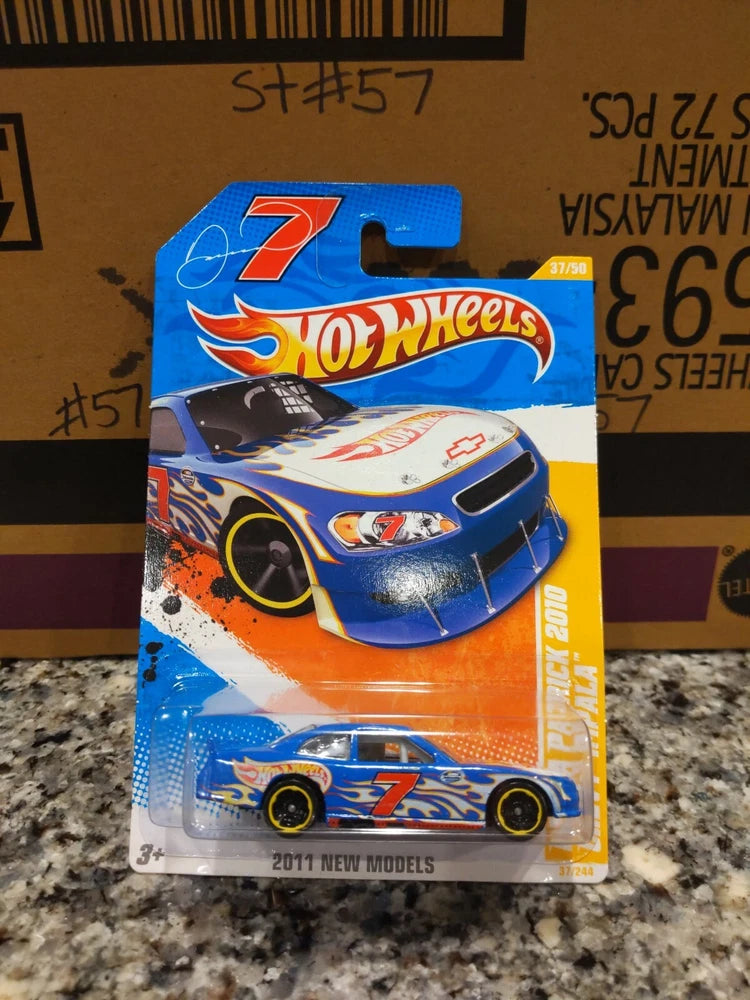 Hot Wheels die-cast car blister pack with blue car, number 7, orange flame graphics
