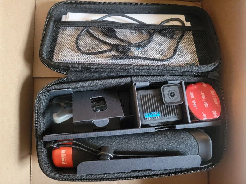 Action camera accessory bundle in zippered case with mounts, red battery, and waterproof housing