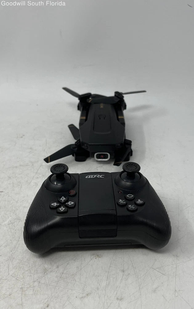 Foldable black RC quadcopter drone with remote controller, four prop arms visible