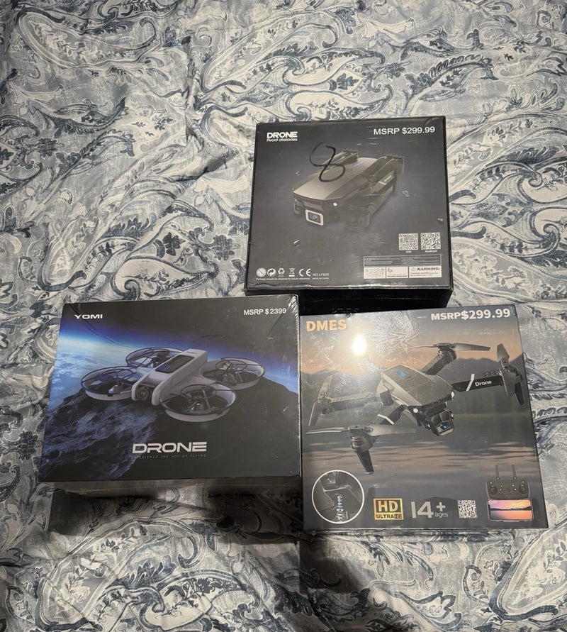 Assorted drone product boxes, including YOMI and DMES models, in retail packaging