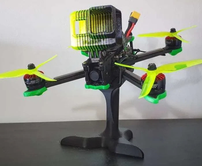 FPV racing drone stand with upright pole and tripod base holding a quadcopter