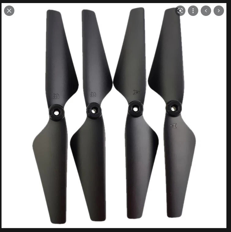 Set of four black drone propeller blades with central mounting holes