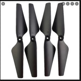 Set of four black drone propeller blades with central mounting holes