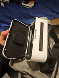 Sharper Image handheld device in black case with white carry strap