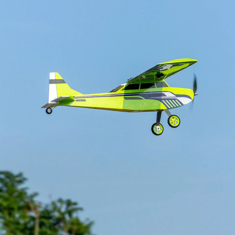RC balsa wood airplane with green and yellow wings and three-wheel landing gear