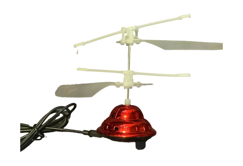 Red RC UFO magic hand toy with two propeller blades and black control cord