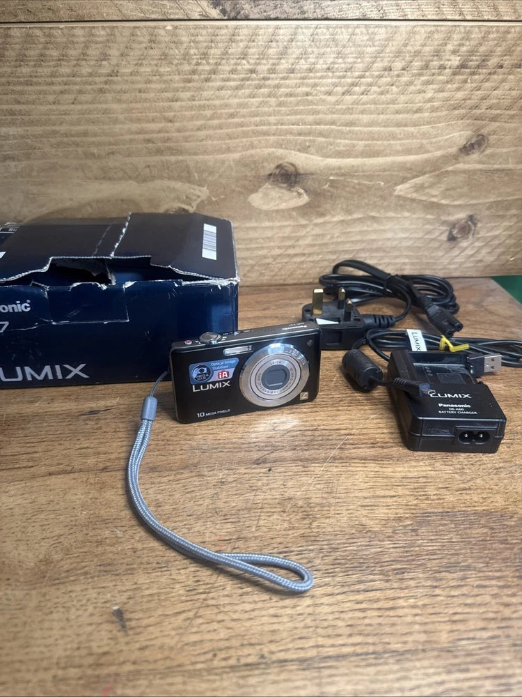 Panasonic Lumix digital camera with charging cable, battery charger, and strap.