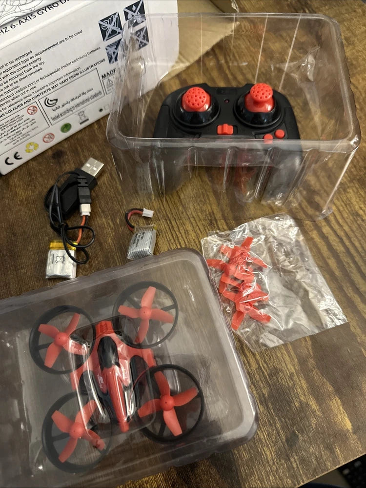 Red mini 2.4 GHz drone with protective clear packaging and red prop guards