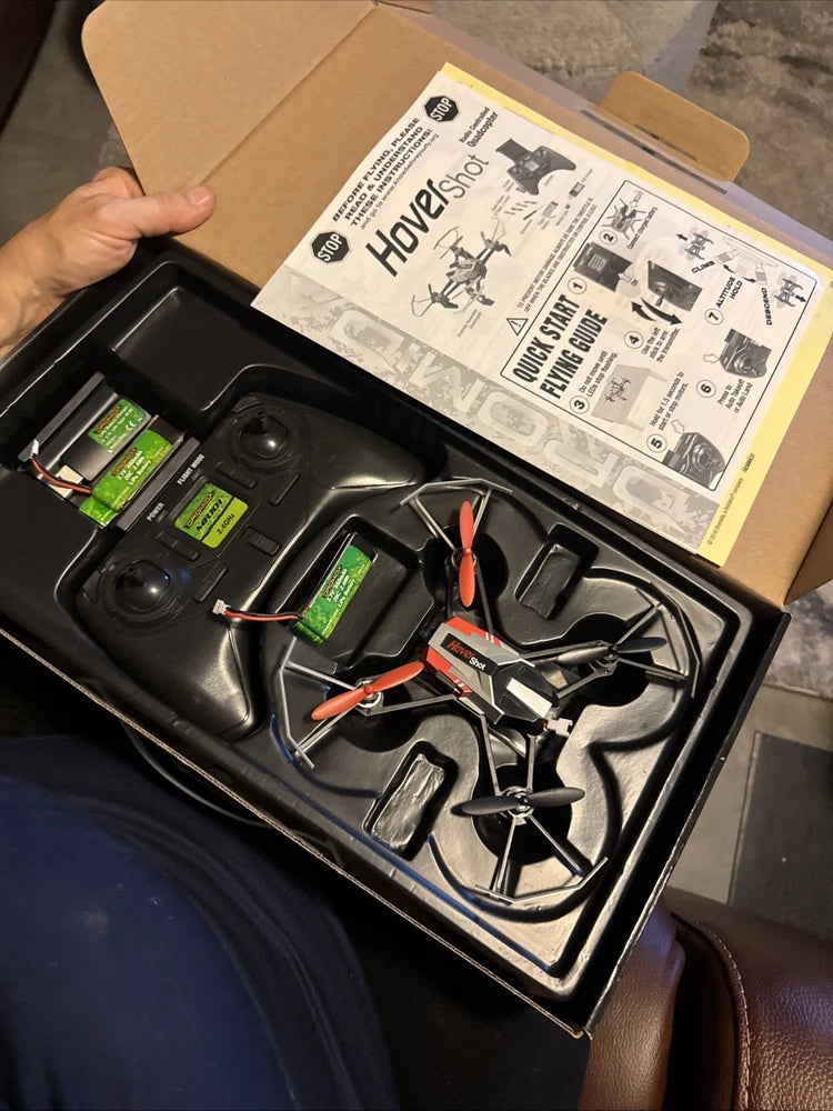 FPV drone quadcopter with orange motor accents in open retail box