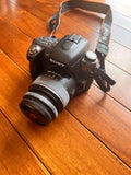 Sony digital SLR camera with standard and telephoto zoom lenses and neck strap