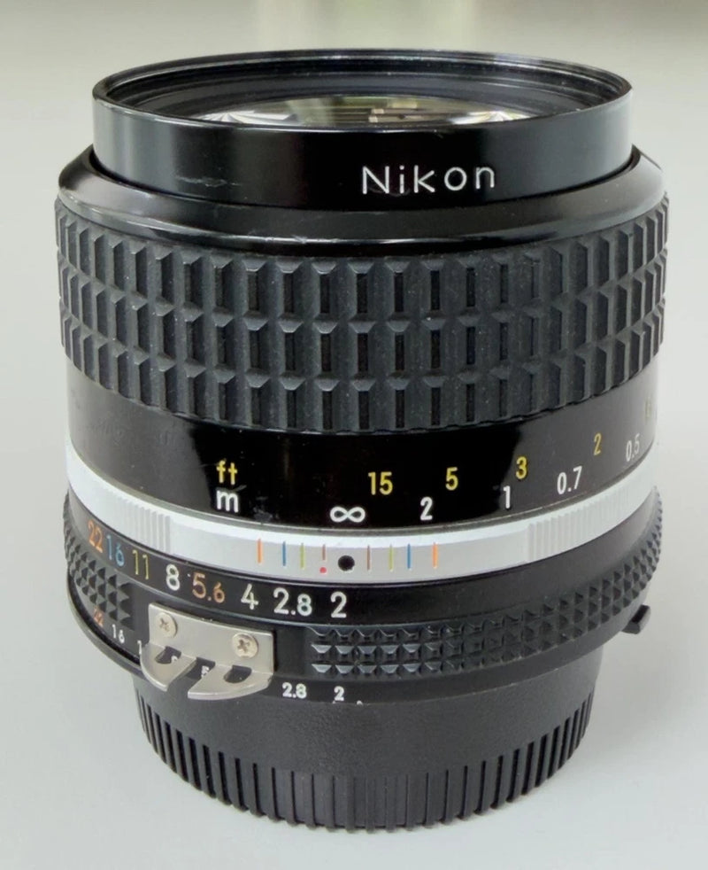 Black Nikon 35mm F2 Nikkor lens with textured focus and distance scale rings