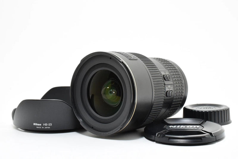 Nikon AF-S camera lens with hood and front cap, dark gray with glass front