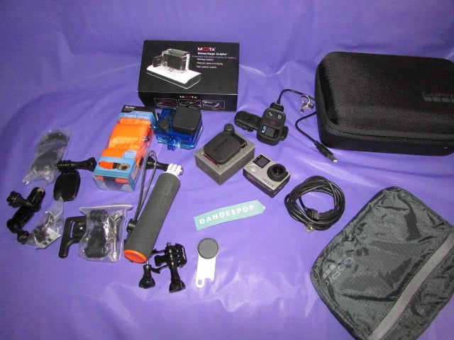 Silver action camcorder kit with accessories, mounts, remote, and storage case.