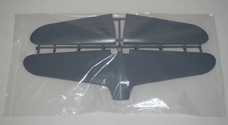 Dark blue model airplane wing parts on clear sprue in plastic bag