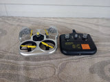 Toy RC racing drone with white frame and yellow propellers plus black remote controller