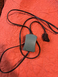 Battery charger adapter with gray power brick and black power cord with plug