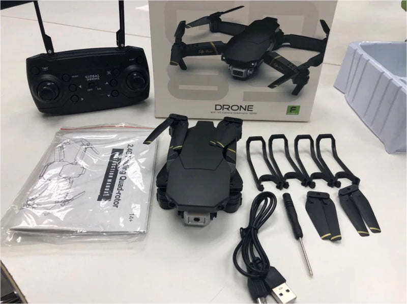 FPV drone kit with controller, foldable quadcopter, propellers, cables, and battery.