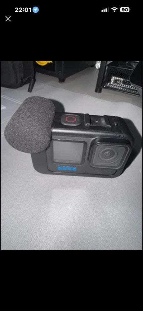 Black action camera with front lens and built-in screen, in protective housing