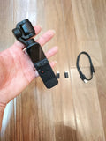 Handheld gimbal camera stabilizer with mounted camera, held in a person’s hand